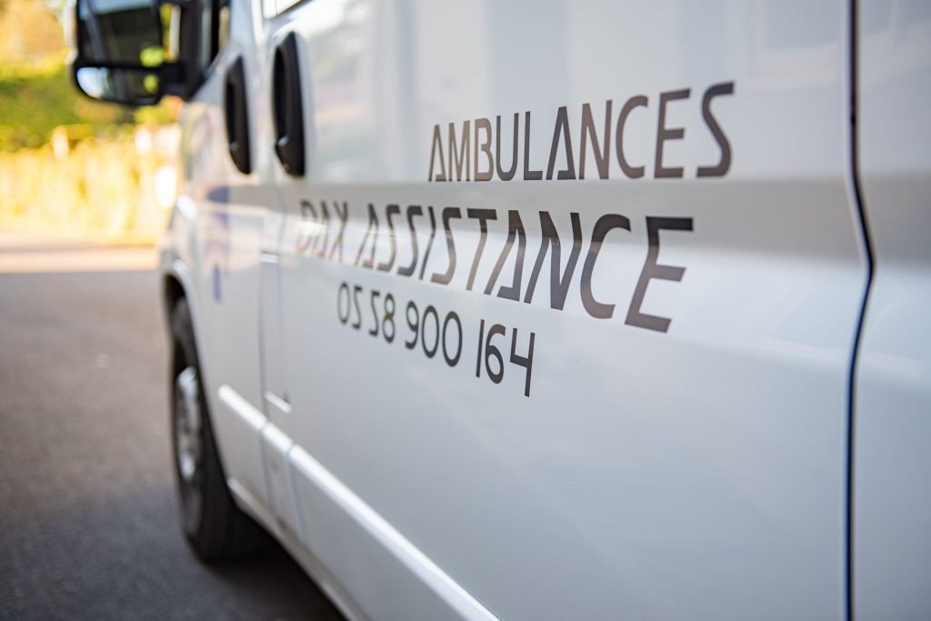 Flanc d'un véhicule Ambulances Dax Assistance avec le numéro