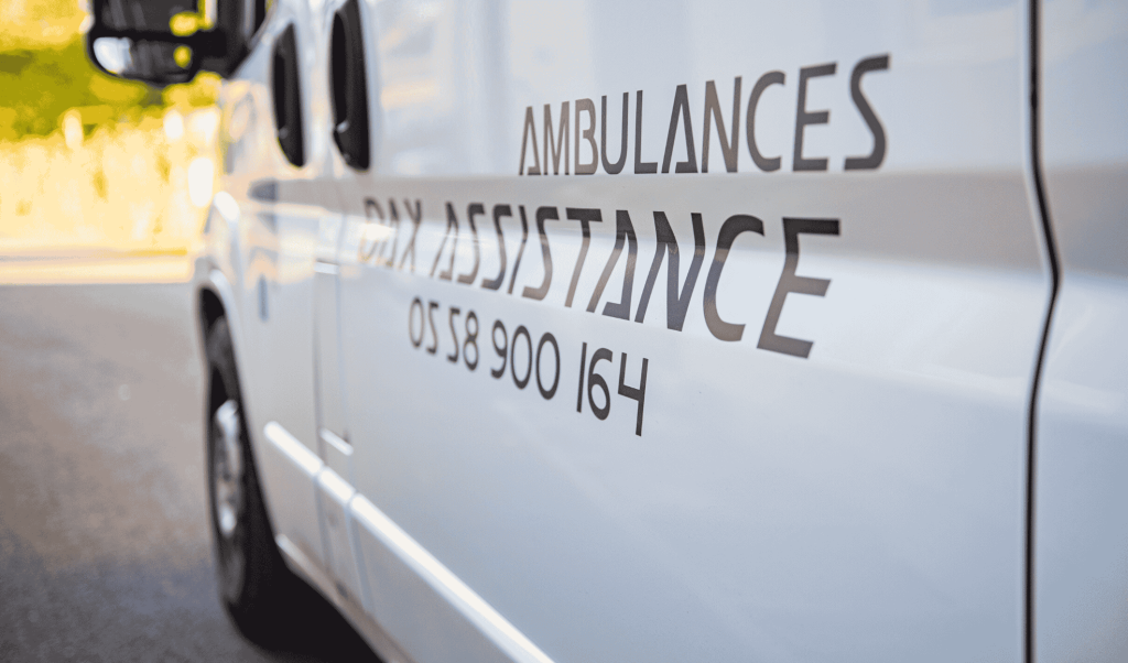 Flanc d'un véhicule Ambulances Dax Assistance avec le numéro 05 58 900 164, transport sanitaire sur Dax, Bayonne et Mont-de-Marsan