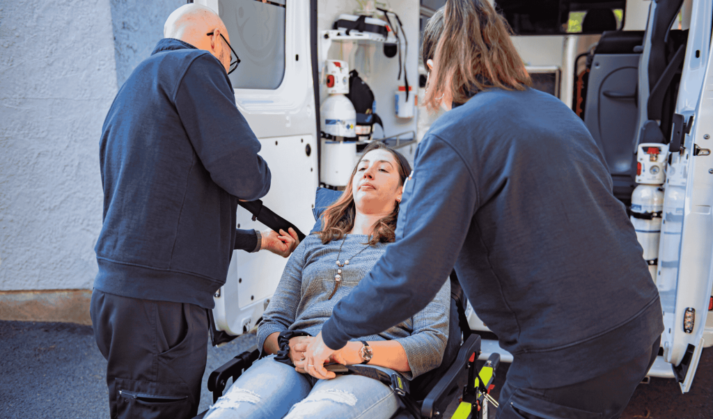 Deux ambulanciers diplômés Dax Assistance installant une patiente sur brancard devant une ambulance équipée, transport sanitaire à Dax, Bayonne et Mont-de-Marsan